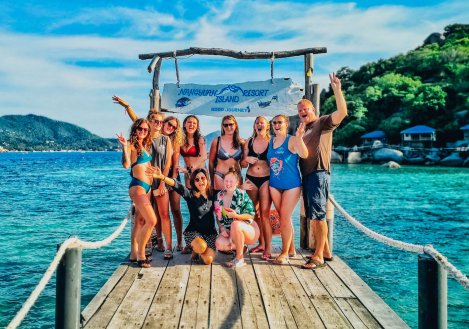 Group photo by crystal clear blue waters in Koh Tao