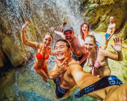 A group selfie under the waterfall at Erawan falls in Thailand 