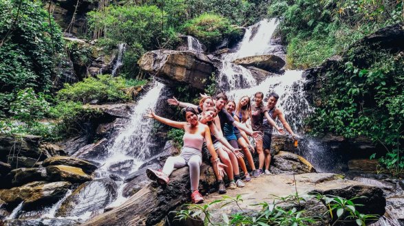 A group photo at a waterfall during the hill tribe trek in Northern Thailand
